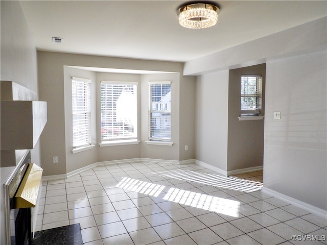 unfurnished dining area featuring a healthy amount of sunlight and light tile patterned floors