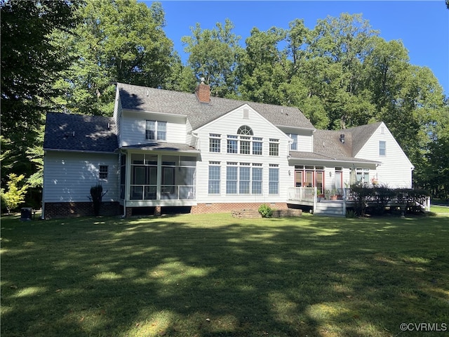 rear view of house with a yard, a sunroom, and a wooden deck