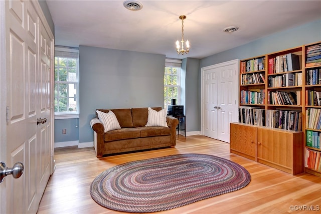 living area featuring an inviting chandelier and light hardwood / wood-style floors