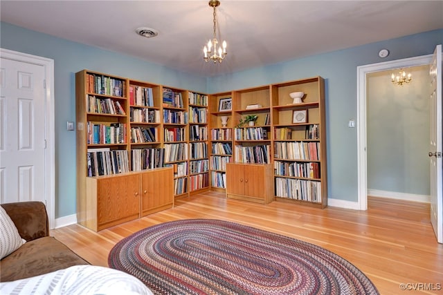 sitting room featuring hardwood / wood-style floors and an inviting chandelier