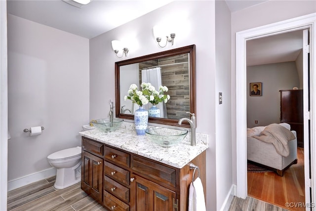 bathroom featuring toilet, vanity, and hardwood / wood-style floors