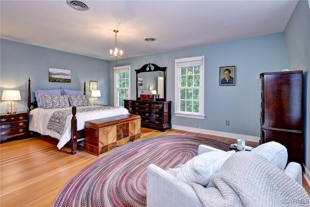 bedroom featuring light wood-type flooring and a chandelier