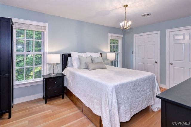 bedroom with a notable chandelier and light hardwood / wood-style floors