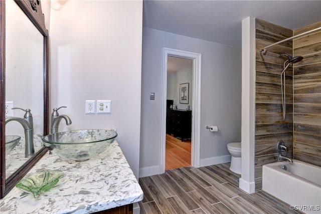 full bathroom featuring wood-type flooring, vanity, toilet, and tiled shower / bath combo