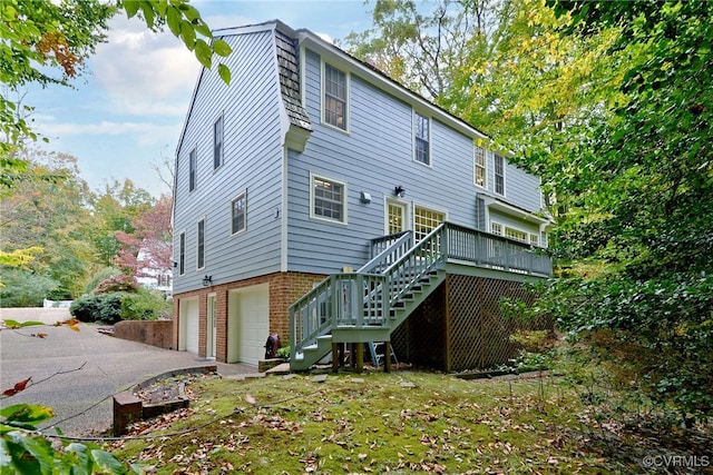 rear view of property featuring a deck and a garage