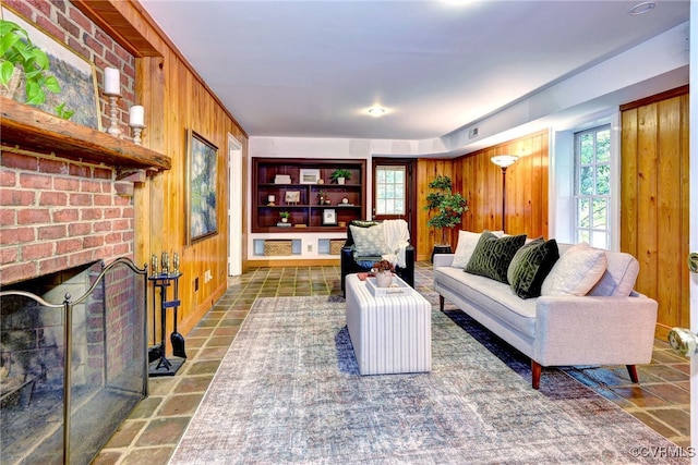 living room featuring wood walls and a fireplace