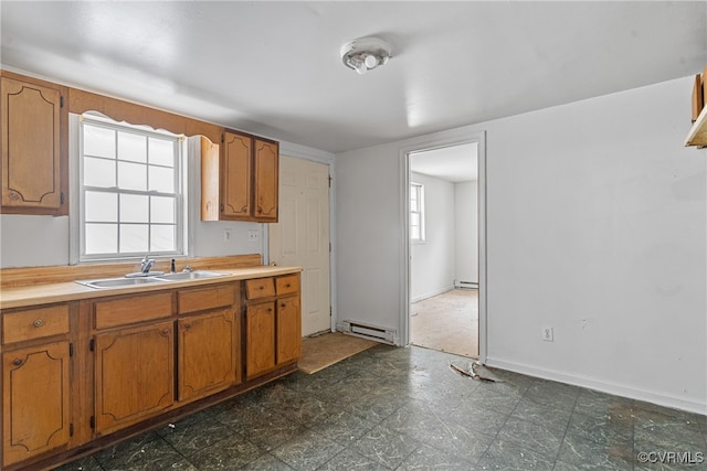 kitchen featuring baseboard heating, a healthy amount of sunlight, and sink