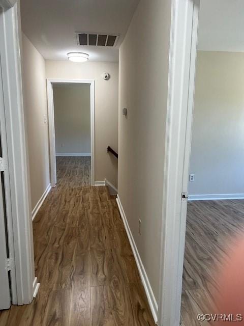 corridor with dark hardwood / wood-style flooring