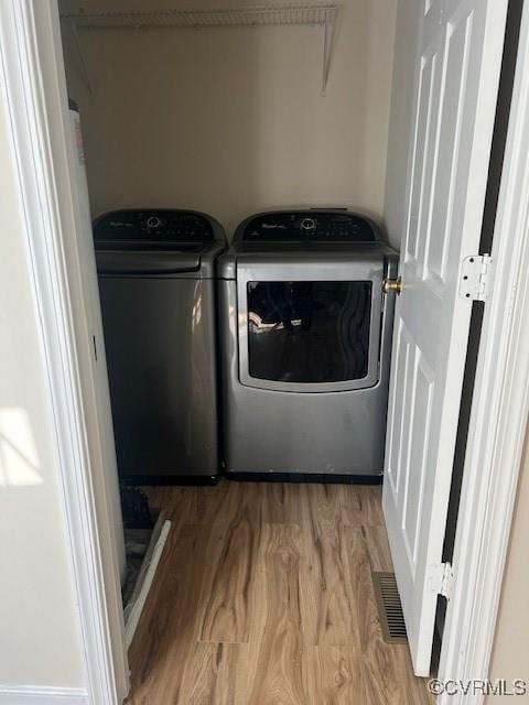 laundry room featuring hardwood / wood-style floors and separate washer and dryer