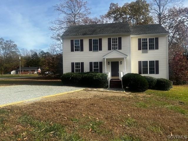 colonial-style house with a front lawn