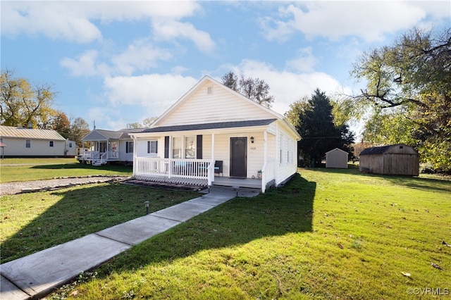 bungalow-style house with covered porch, a front lawn, and a storage shed