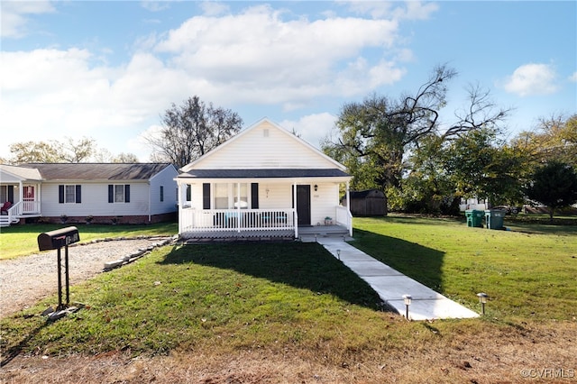 view of front of home featuring a porch, a front lawn, and a storage shed