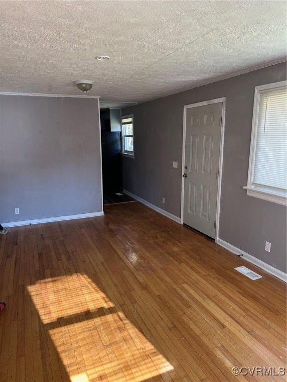 unfurnished room with a textured ceiling and wood-type flooring