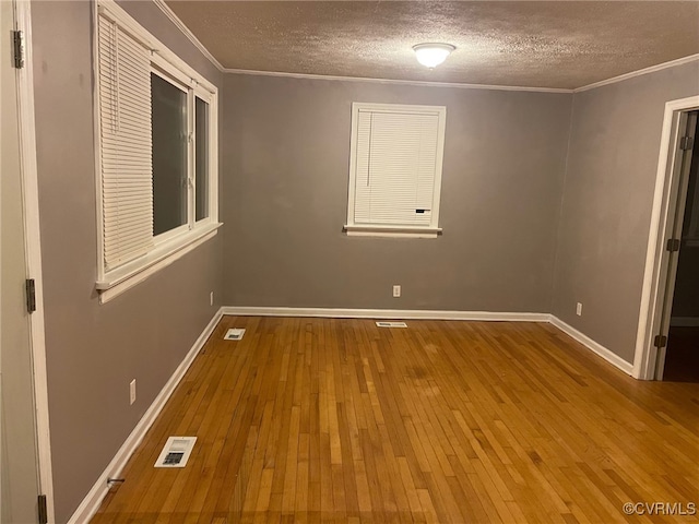 unfurnished bedroom with a closet, a textured ceiling, wood-type flooring, and ornamental molding