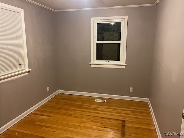 unfurnished room featuring ornamental molding and hardwood / wood-style floors