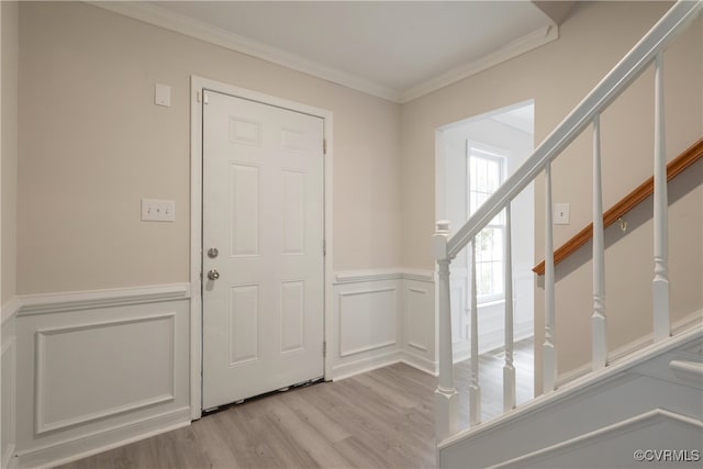 foyer with light hardwood / wood-style flooring and ornamental molding