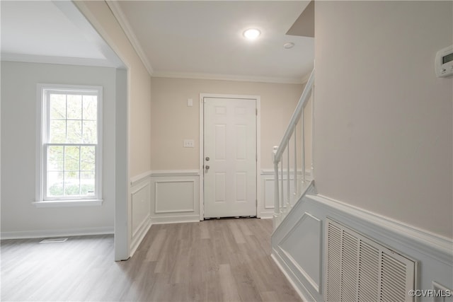 entryway with crown molding and light hardwood / wood-style flooring