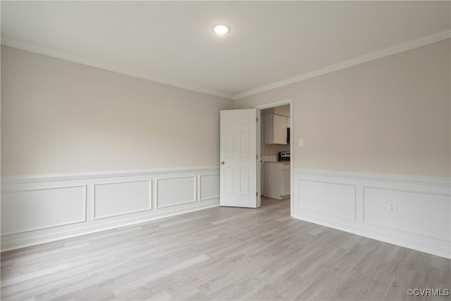 empty room featuring crown molding and light hardwood / wood-style floors