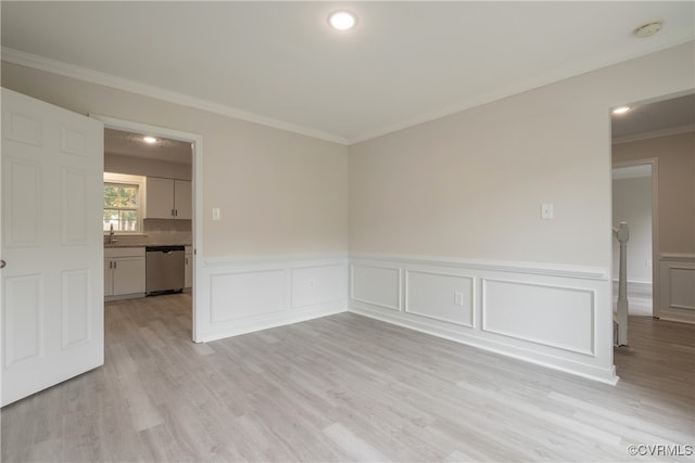 unfurnished room featuring light hardwood / wood-style flooring, ornamental molding, and sink