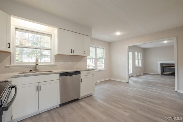 kitchen with sink, white cabinetry, stainless steel appliances, and light wood-type flooring