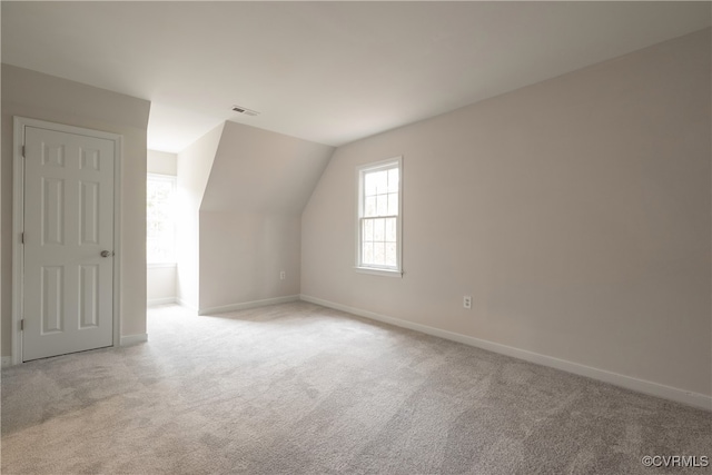 bonus room featuring lofted ceiling and light colored carpet