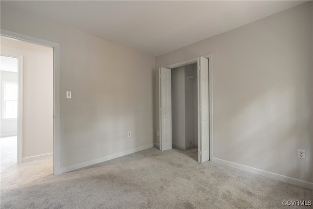 unfurnished bedroom featuring light colored carpet and a closet