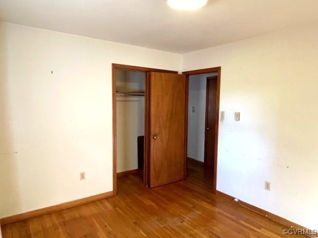 unfurnished bedroom featuring hardwood / wood-style floors and a closet