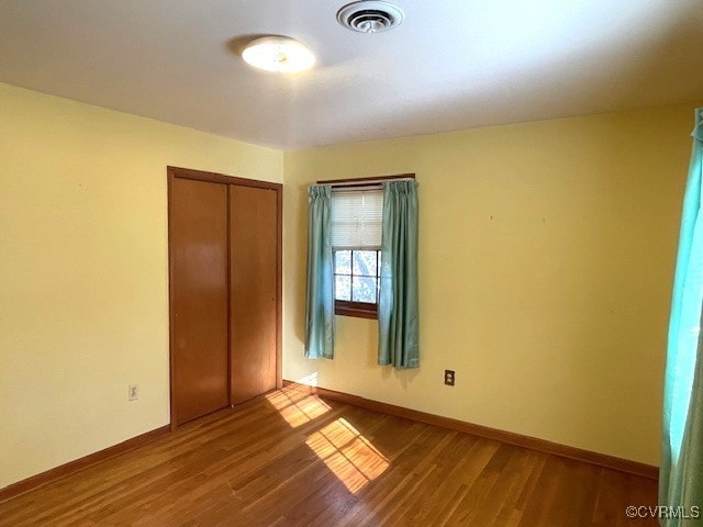 unfurnished bedroom featuring a closet and hardwood / wood-style floors