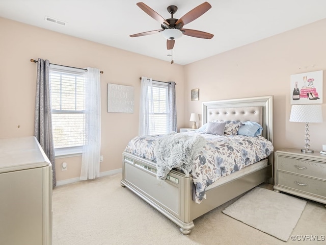 carpeted bedroom with multiple windows and ceiling fan