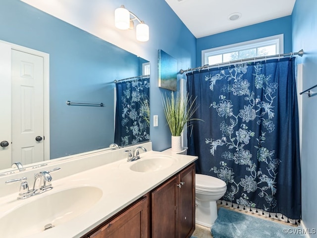 bathroom with vanity, toilet, and curtained shower