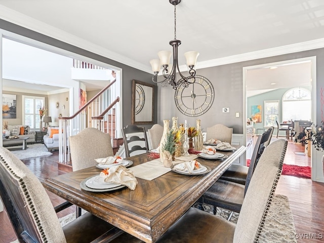 dining area with dark hardwood / wood-style flooring, a notable chandelier, and ornamental molding