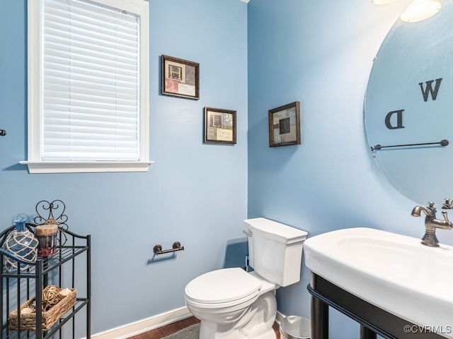 bathroom featuring wood-type flooring, toilet, and sink