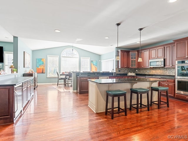 kitchen featuring tasteful backsplash, stainless steel appliances, dark hardwood / wood-style floors, and lofted ceiling