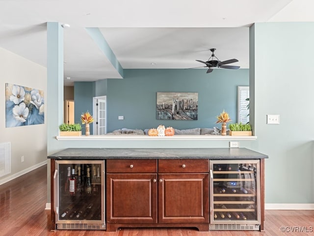 bar featuring ceiling fan, hardwood / wood-style floors, and beverage cooler