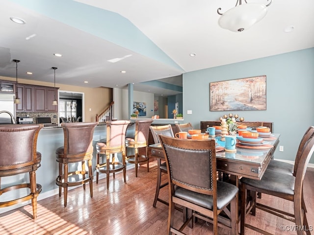 dining space featuring light hardwood / wood-style floors and vaulted ceiling