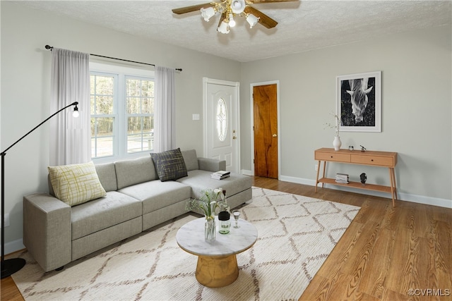 living room featuring hardwood / wood-style floors, a textured ceiling, and ceiling fan