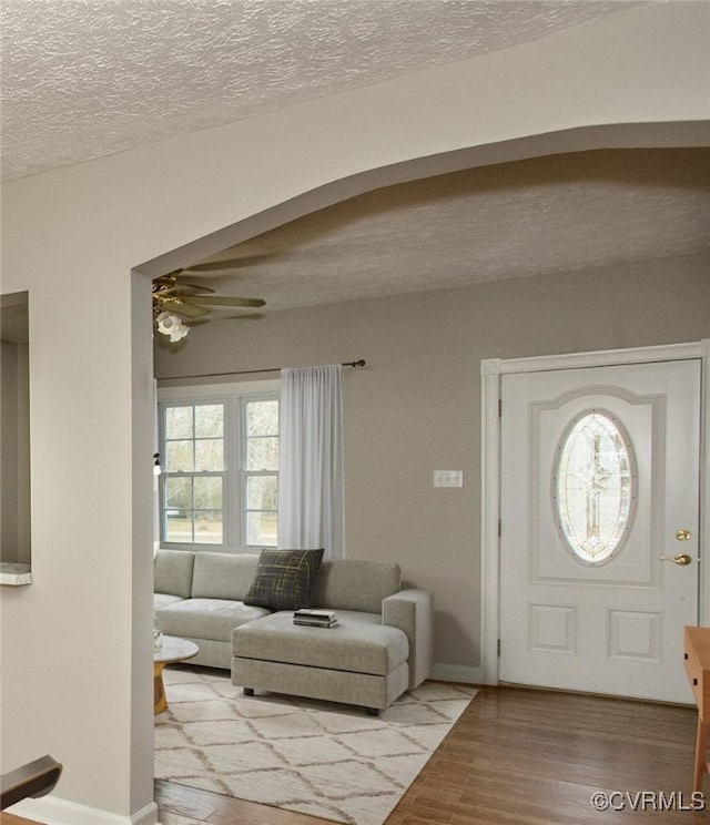 entrance foyer with ceiling fan, a textured ceiling, and light hardwood / wood-style flooring