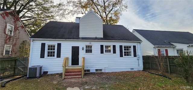 back of house featuring a yard and central AC