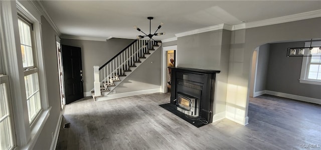 unfurnished living room featuring ornamental molding, a chandelier, and hardwood / wood-style flooring