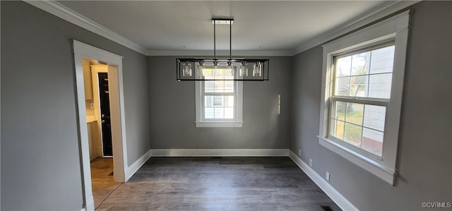 unfurnished dining area featuring a notable chandelier, ornamental molding, and dark hardwood / wood-style flooring