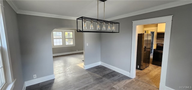 unfurnished dining area featuring crown molding and hardwood / wood-style floors