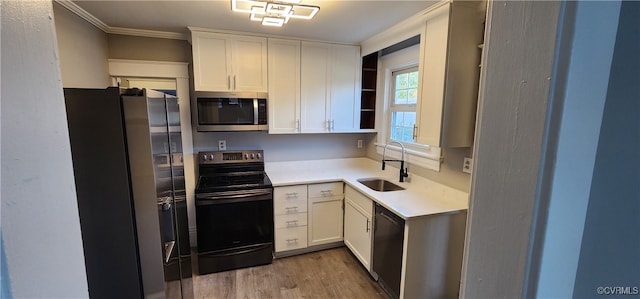 kitchen with light hardwood / wood-style flooring, white cabinetry, black appliances, and sink