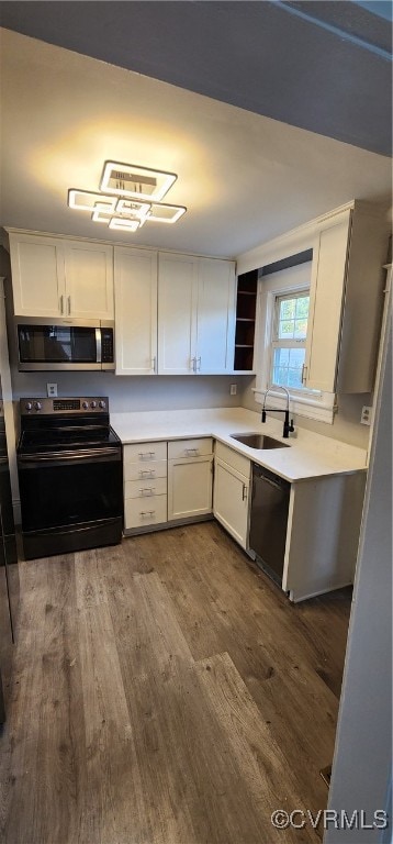 kitchen featuring sink, black appliances, white cabinetry, and dark wood-type flooring