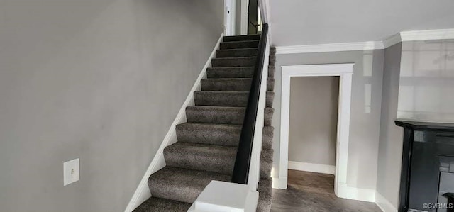 stairs featuring crown molding and concrete flooring