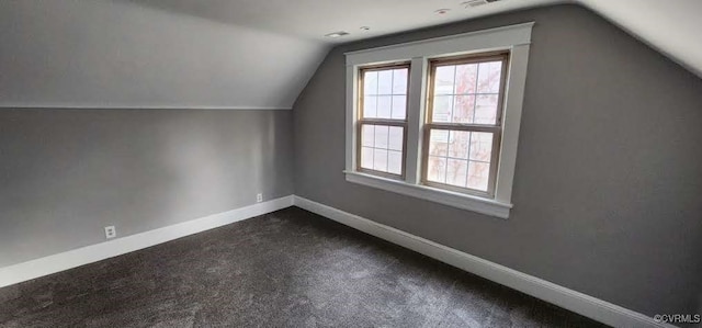 bonus room featuring vaulted ceiling and dark colored carpet