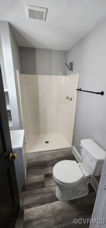 bathroom with vanity, hardwood / wood-style floors, toilet, and walk in shower