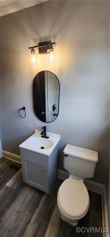 bathroom with vanity, hardwood / wood-style flooring, and toilet