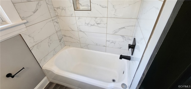 bathroom with tiled shower / bath combo and hardwood / wood-style flooring