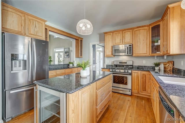 kitchen featuring an inviting chandelier, hanging light fixtures, wine cooler, light hardwood / wood-style flooring, and appliances with stainless steel finishes