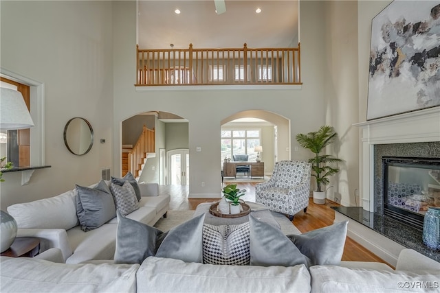 living room with light wood-type flooring and a high ceiling